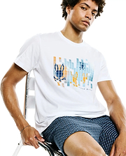 Mens Zander Graphic Tee, a white classic fit jersey t-shirt with a prominent pixelated blue and orange Psycho Bunny skull graphic on the chest, featuring subtle brand text below.