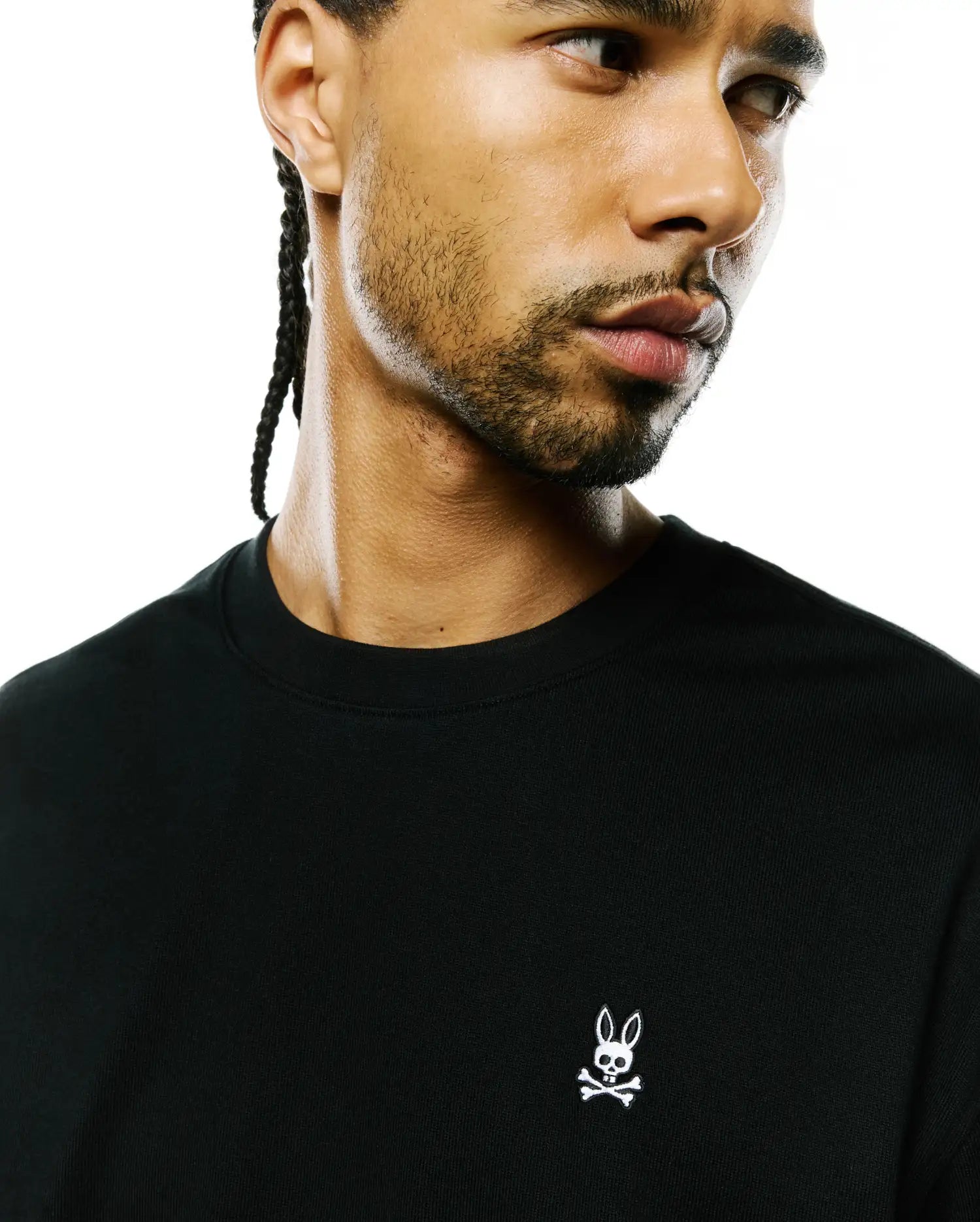 Mens Norman Long Sleeve Oversized Fit Tee in black premium jersey knit, featuring a small, white embroidered iconic Psycho Bunny skull logo prominently on the left chest.