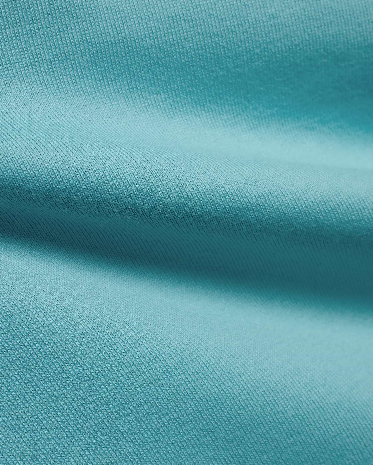 Men's Norman Longsleeve Oversized Tee in a vibrant aqua hue, highlighting the premium, soft jersey knit fabric with a smooth, comfortable texture and subtle draping. (6)