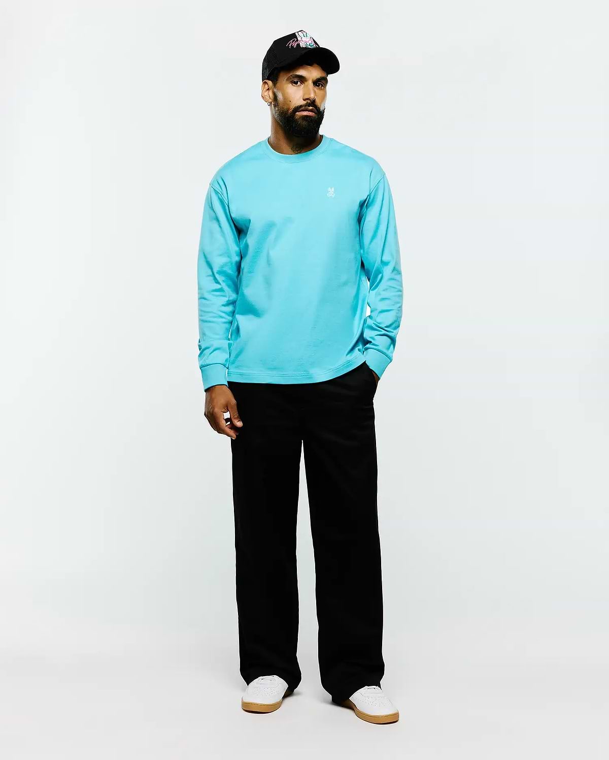 Mens Norman Long Sleeve Relaxed Fit Tee in vibrant aqua blue, crafted from smooth jersey fabric with a relaxed fit and a small white embroidered Psycho Bunny skull logo on the left chest.