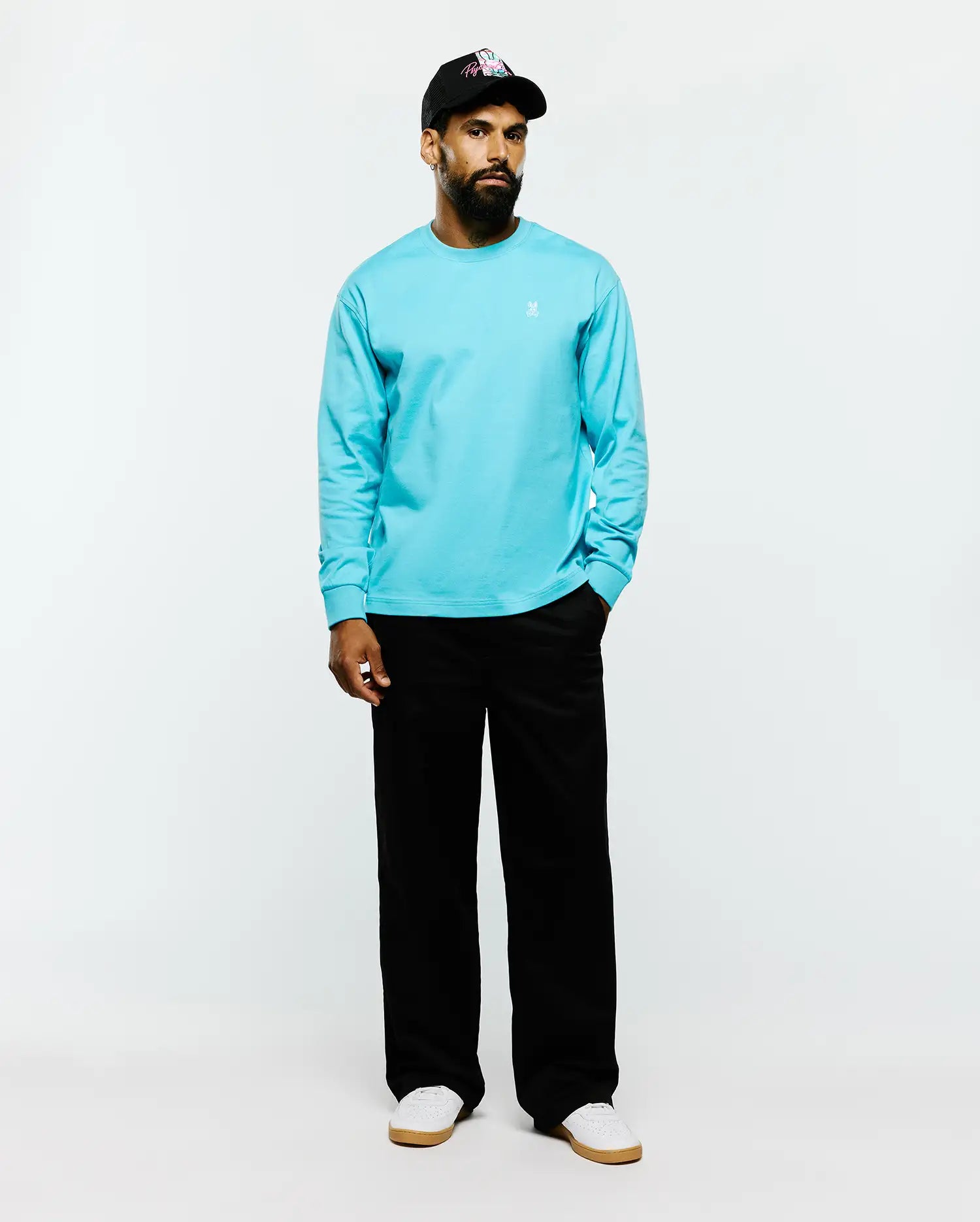Mens Norman Long Sleeve Relaxed Fit Tee in vibrant aqua blue, crafted from smooth jersey fabric with a relaxed fit and a small white embroidered Psycho Bunny skull logo on the left chest.