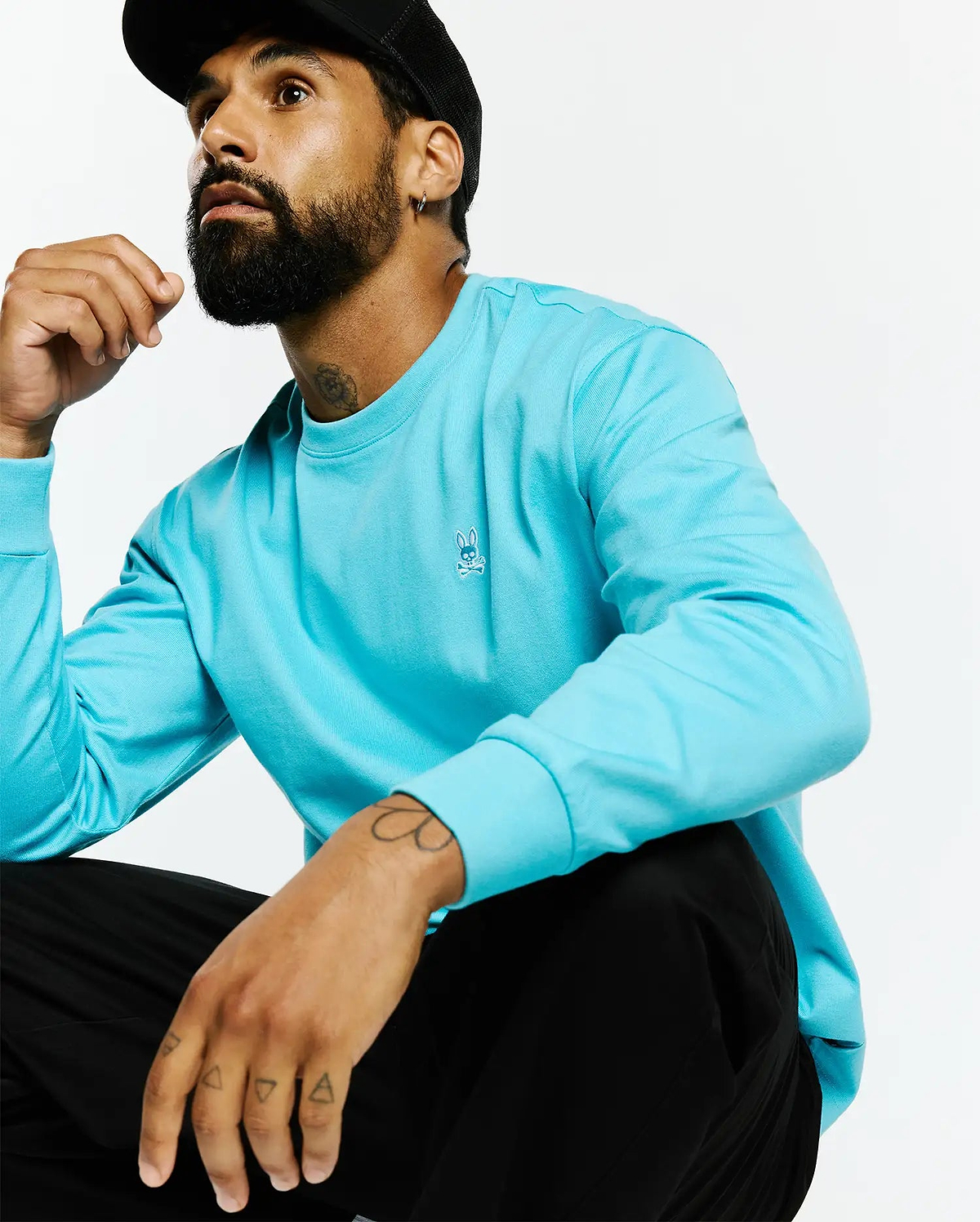 Mens Norman Long Sleeve Relaxed Fit Tee in vibrant aqua smooth jersey knit, featuring a small white embroidered Psycho Bunny skull logo on the left chest.