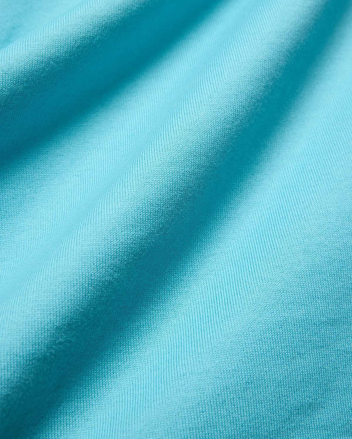 Mens Norman Long Sleeve Relaxed Fit Tee in vibrant aqua jersey knit, highlighting its soft, finely textured fabric with subtle vertical ribbing and gentle folds.