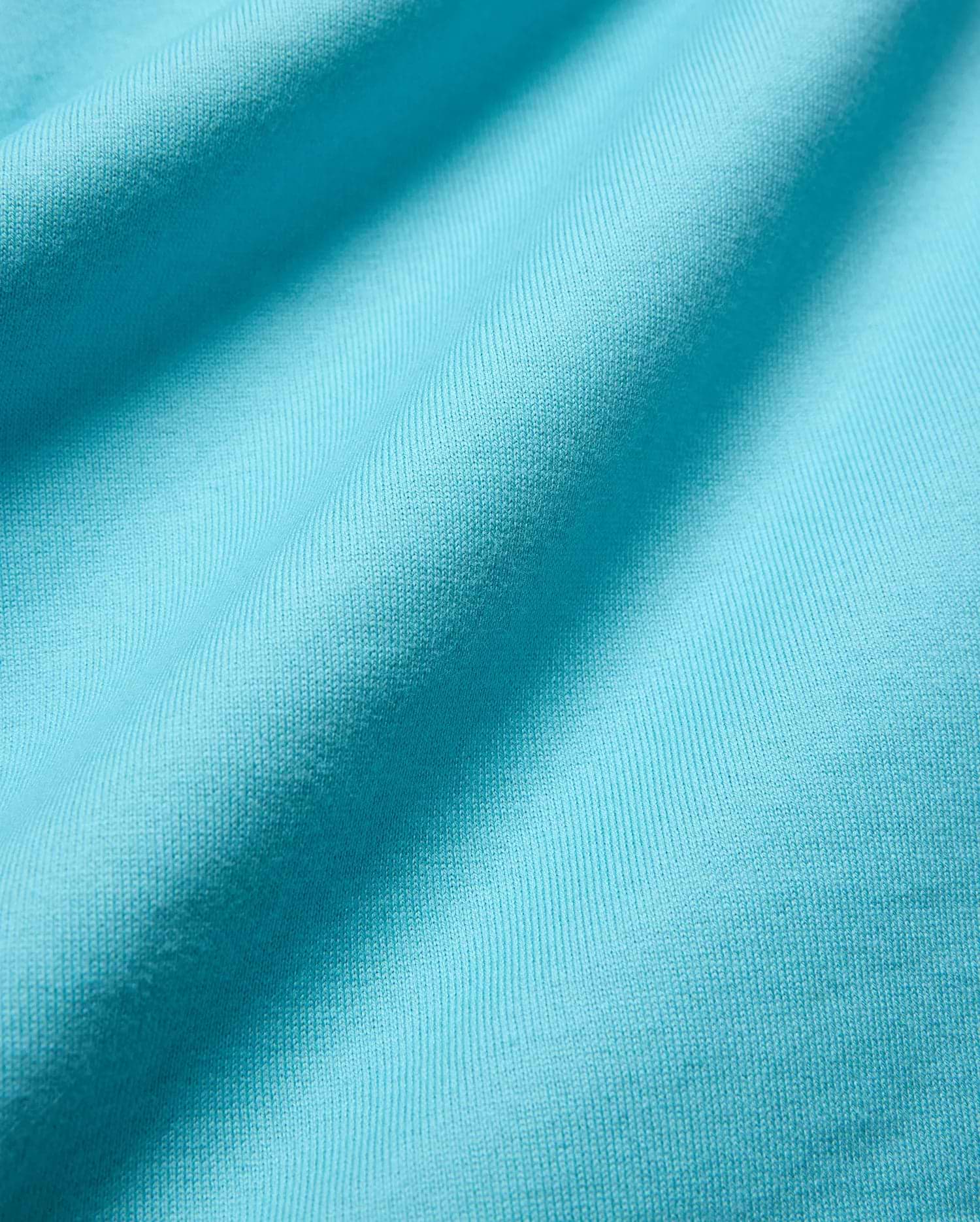 Mens Norman Long Sleeve Relaxed Fit Tee in vibrant aqua jersey knit, highlighting its soft, finely textured fabric with subtle vertical ribbing and gentle folds.