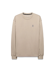 Mens Norman Long Sleeve Relaxed Fit Tee in beige, crafted from soft jersey knit, featuring a small, iconic embroidered Psycho Bunny skull logo on the left chest.