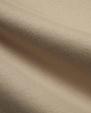 Mens Norman Long Sleeve Relaxed Fit Tee, crafted from a premium, soft beige jersey knit fabric, showcasing its refined texture and comfortable drape in a close-up detail.