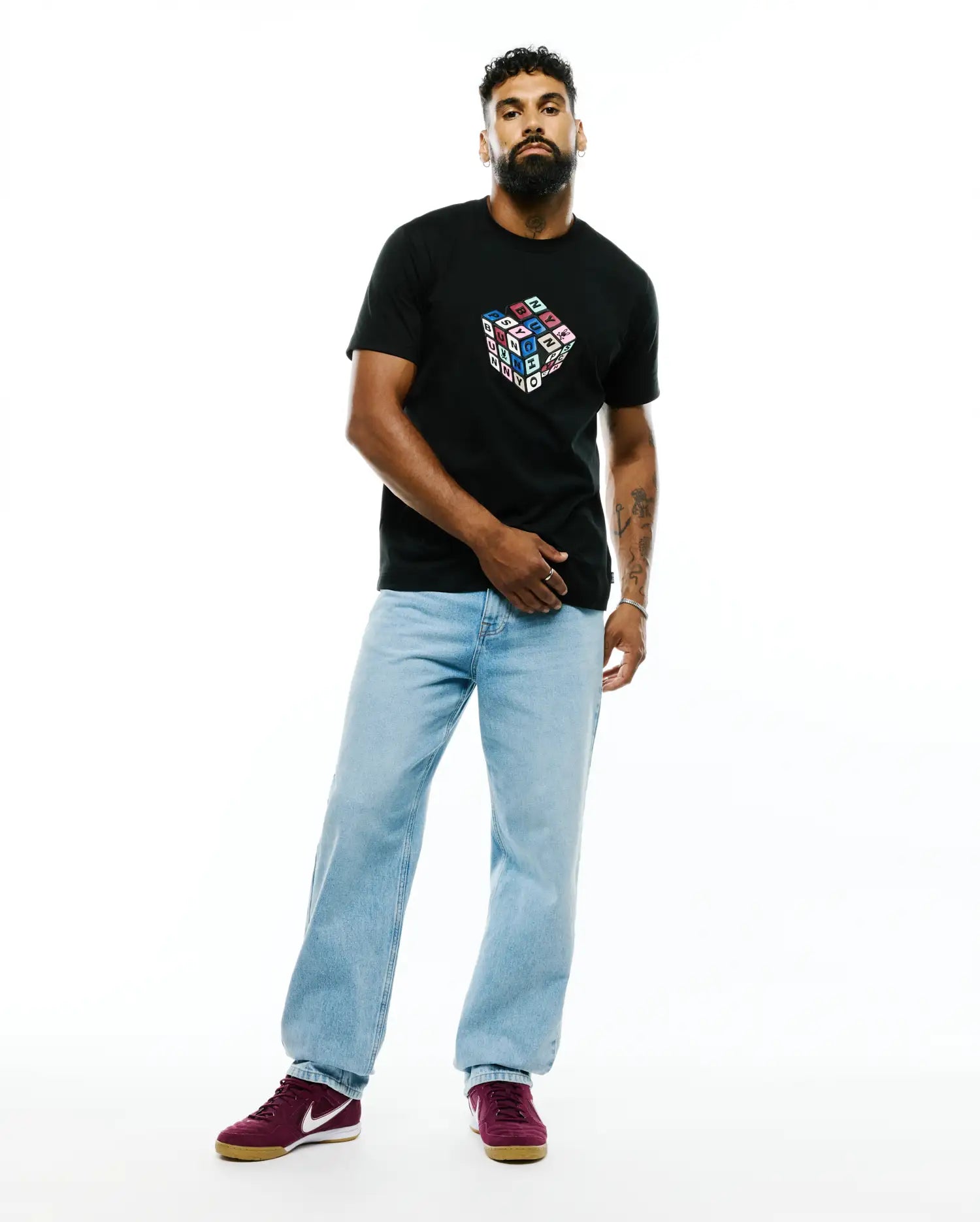 Mens Eddy Graphic Tee, a black classic fit jersey t-shirt featuring a large, colorful Rubik's Cube-style graphic on the chest spelling PSYCHO BUNNY in bright block letters.