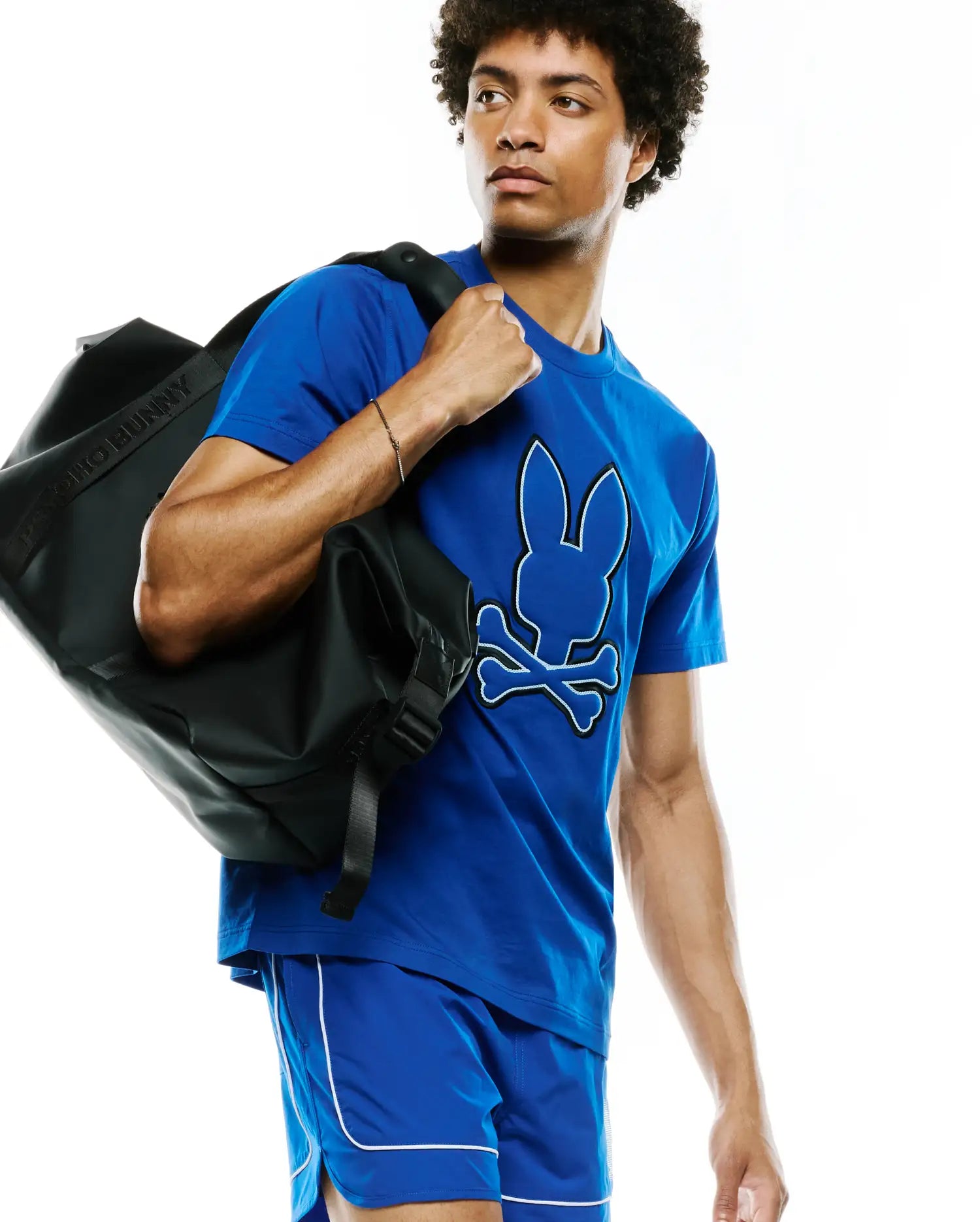 Mens Bruno Graphic Tee in royal blue, featuring a large white and black outlined Psycho Bunny skull logo on the center chest, crafted from soft jersey knit with a classic fit.
