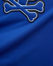Royal blue Mens Bruno Graphic Tee in soft jersey, featuring a large embroidered Psycho Bunny skull logo with black outline and intricate white chain stitching.