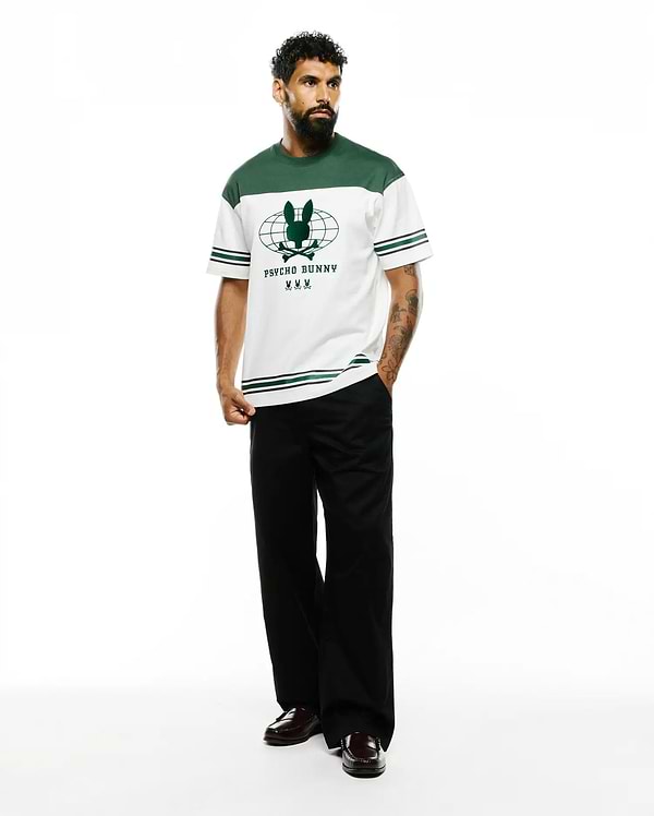 Mens Mike Graphic Jersey Tee, a white and green color block jersey t-shirt with a large central green Psycho Bunny skull and globe graphic, featuring striped sleeves and a classic fit.
