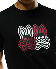 Mens Ledger Graphic Tee, a black jersey knit t-shirt with a classic fit, featuring a large textured chest graphic of two Psycho Bunny skull logos, one red and black, one white and black, with Psycho Bunny text below.
