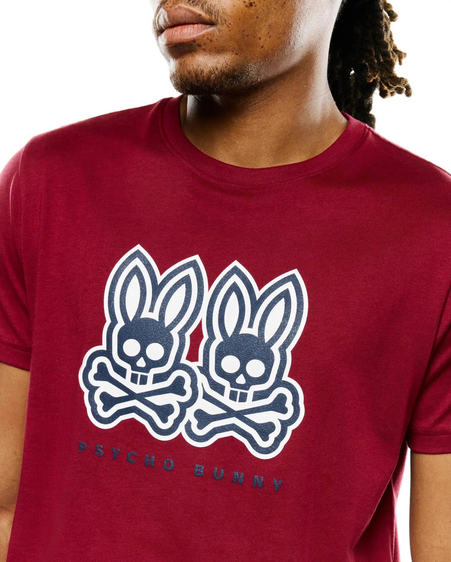 Mens Ledger Graphic Tee, a classic fit deep red jersey t-shirt with a large central navy and white double Psycho Bunny skull and crossbones graphic print and PSYCHO BUNNY text.