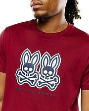 Mens Ledger Graphic Tee, a classic fit deep red jersey t-shirt with a large central navy and white double Psycho Bunny skull and crossbones graphic print and PSYCHO BUNNY text.