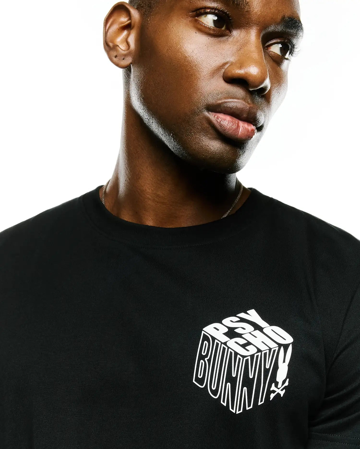 Men's Conan Pima Back Graphic Tee, black classic fit Pima cotton jersey t-shirt with a white 3D-effect Psycho Bunny text logo and small bunny skull on the left chest.