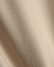 Psycho Bunny Mens Conan Back Graphic Tee in a warm, light beige, showcasing the refined, soft diagonal ribbed knit jersey fabric texture, characteristic of premium streetwear.