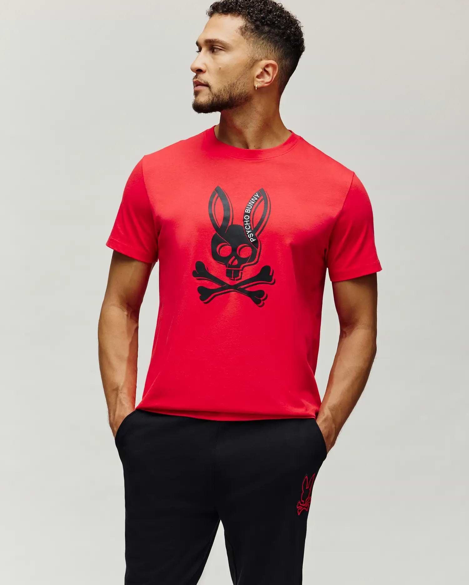 Mens Serge Embroidered Bunny Graphic Tee in vibrant red, featuring a large central black Psycho Bunny skull and crossbones graphic print with curved brand text, on a classic fit smooth jersey knit.