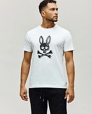 Mens Serge Embroidered Bunny Graphic Tee, a classic fit white jersey knit t-shirt with a large black Psycho Bunny skull and crossbones chest graphic, featuring PSYCHO BUNNY text in the ears, and a small woven brand tag on the left hem.