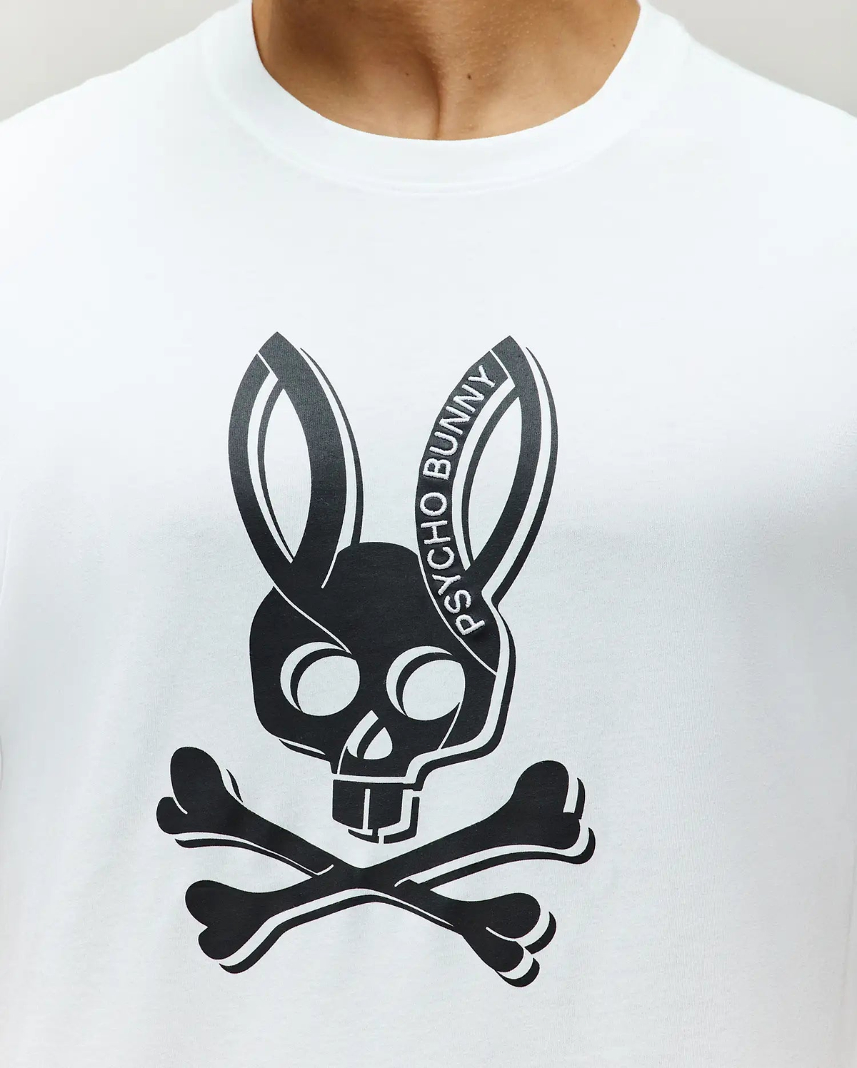 Mens Serge Embroidered Bunny Graphic Tee. White jersey knit t-shirt with a large central black Psycho Bunny skull and crossbones graphic, featuring PSYCHO BUNNY text on the right ear.