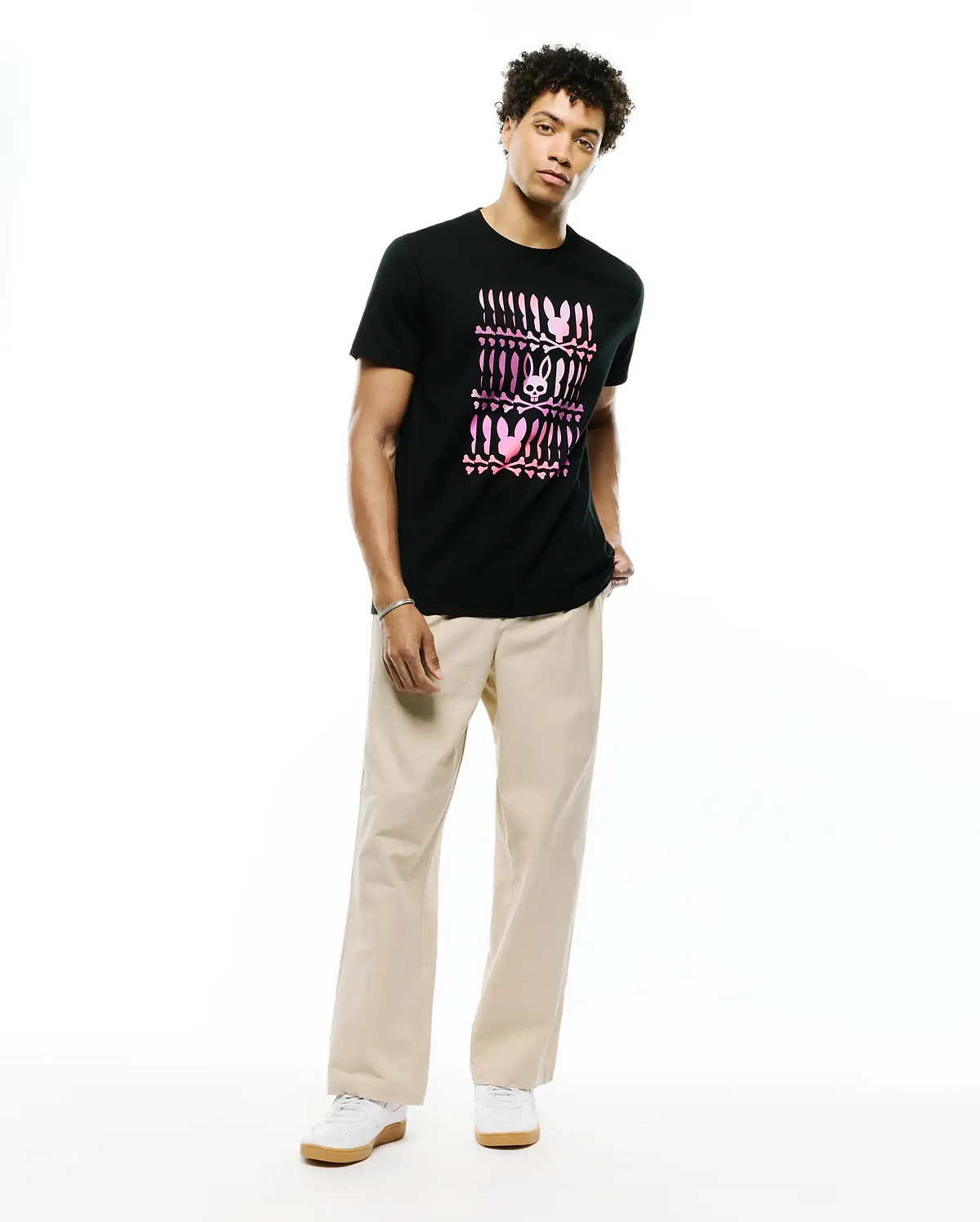 Mens Lewis Graphic Tee: Black jersey knit t-shirt with a classic fit, featuring a large central pink and magenta gradient graphic of repeating Psycho Bunny skull logos and abstract patterns.