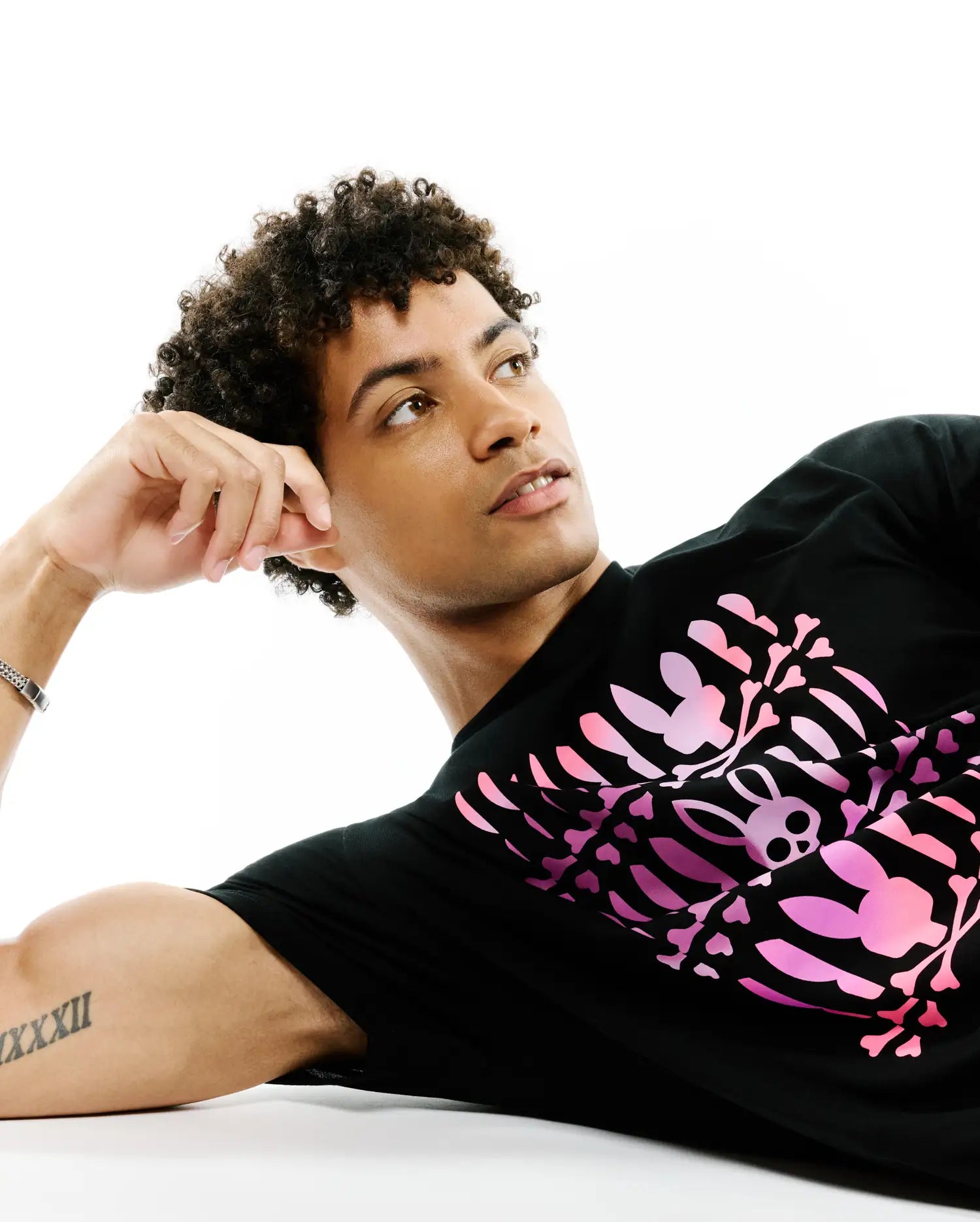Mens Lewis Graphic Tee, black classic fit jersey t-shirt featuring a large pink gradient graphic print of a skeleton rib cage formed by iconic bunny skulls and bones on the front.