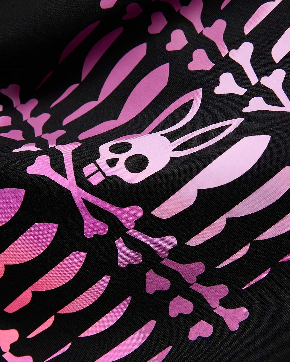 MENS LEWIS GRAPHIC TEE. Black jersey knit fabric with a bold, all-over pink and purple gradient print of stylized bones and the iconic Psycho Bunny skull and crossbones logo.