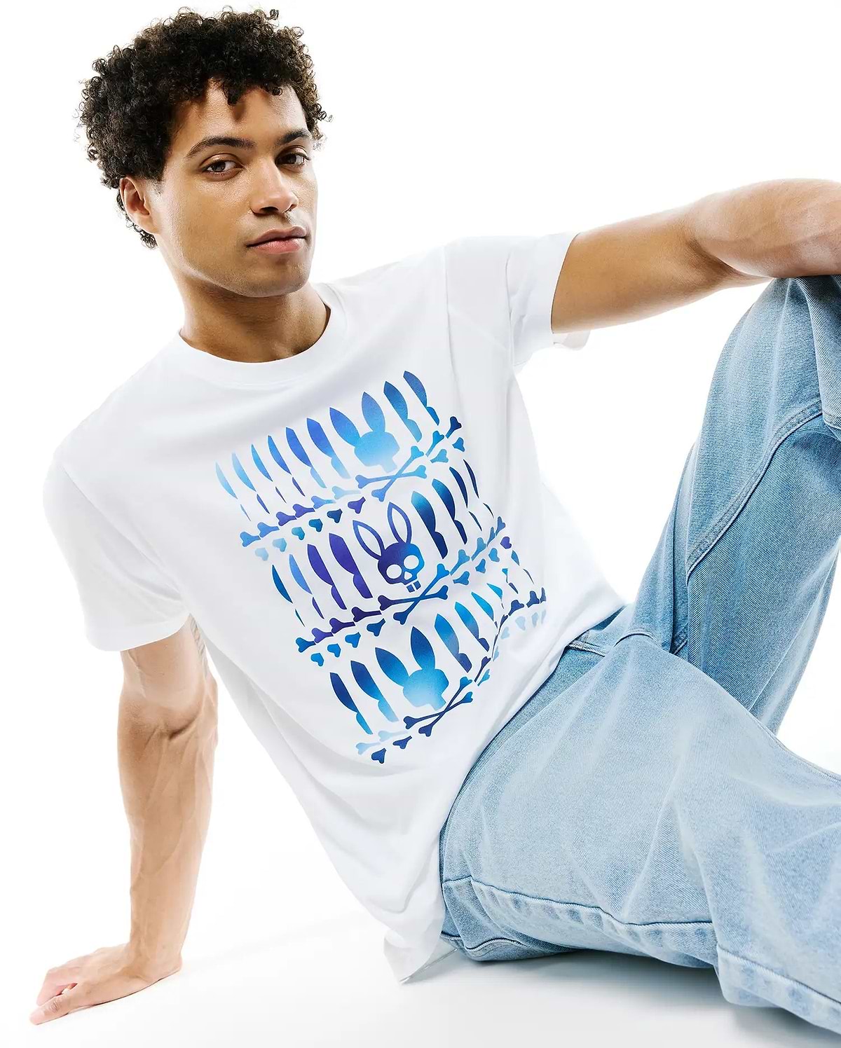 White Mens Lewis Pima Cotton Graphic Tee, classic fit, smooth jersey, with a large central blue and purple gradient Psycho Bunny skull and crossbones graphic pattern.