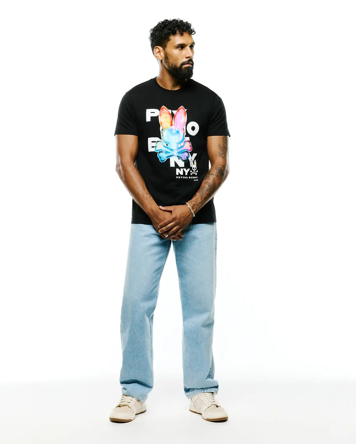 Mens Kenji Pima Cotton Graphic Tee, a classic fit black Pima cotton jersey t-shirt featuring a large, vibrant multicolor Psycho Bunny skull logo and NY text graphic on the chest.