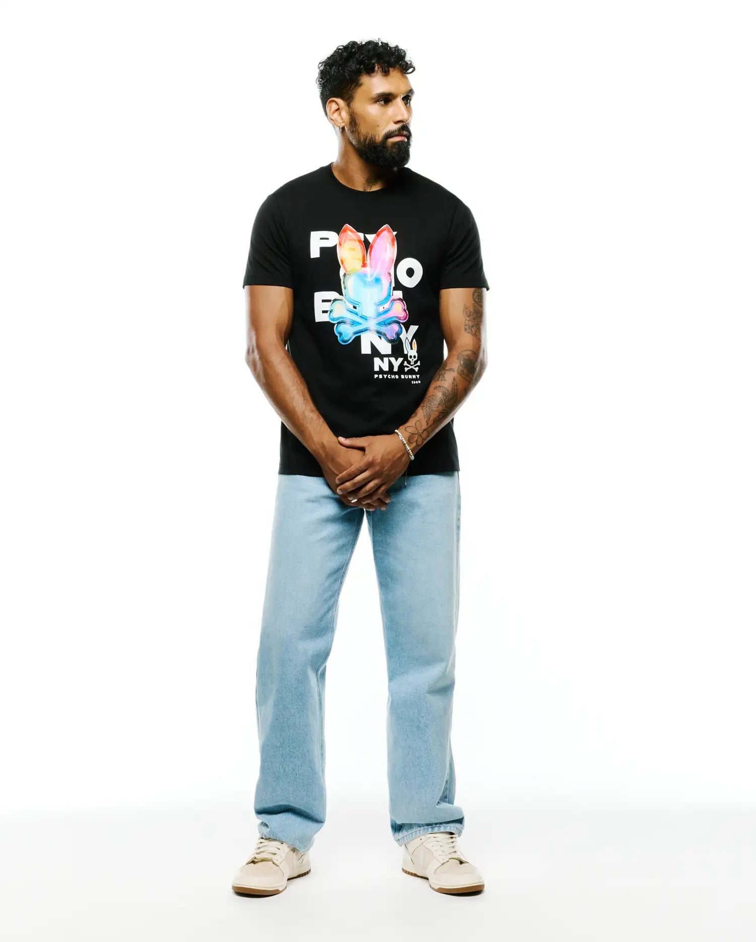 Mens Kenji Pima Cotton Graphic Tee, a classic fit black Pima cotton jersey t-shirt featuring a large, vibrant multicolor Psycho Bunny skull logo and NY text graphic on the chest.