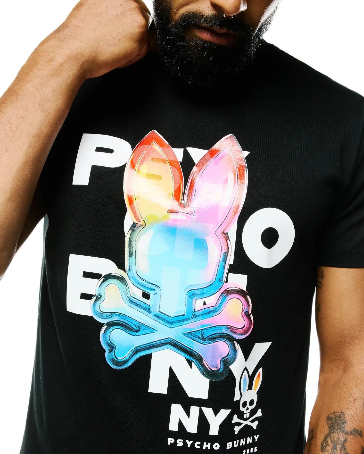 Mens Kenji Pima Cotton Graphic Tee in black, featuring a large iridescent rainbow Psycho Bunny skull logo and white PSYCHO BUNNY text on the chest, with a small classic logo at the hem.