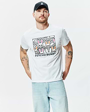 White Mens Byron Graphic Tee, a classic fit jersey t-shirt with a bold chest graphic featuring stylized pink and orange ear bunny skulls, bones, and black Psycho Bunny text. (2)