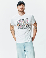 White Mens Byron Graphic Tee, a classic fit jersey t-shirt with a bold chest graphic featuring stylized pink and orange ear bunny skulls, bones, and black Psycho Bunny text. (2)