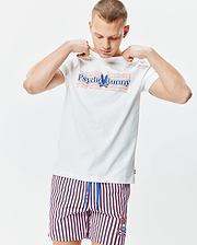 Mens John Back Graphic Tee, a white jersey t-shirt with a large layered red and blue Psycho Bunny chest graphic, paired with red, white, and blue striped shorts featuring a small embroidered bunny skull logo.