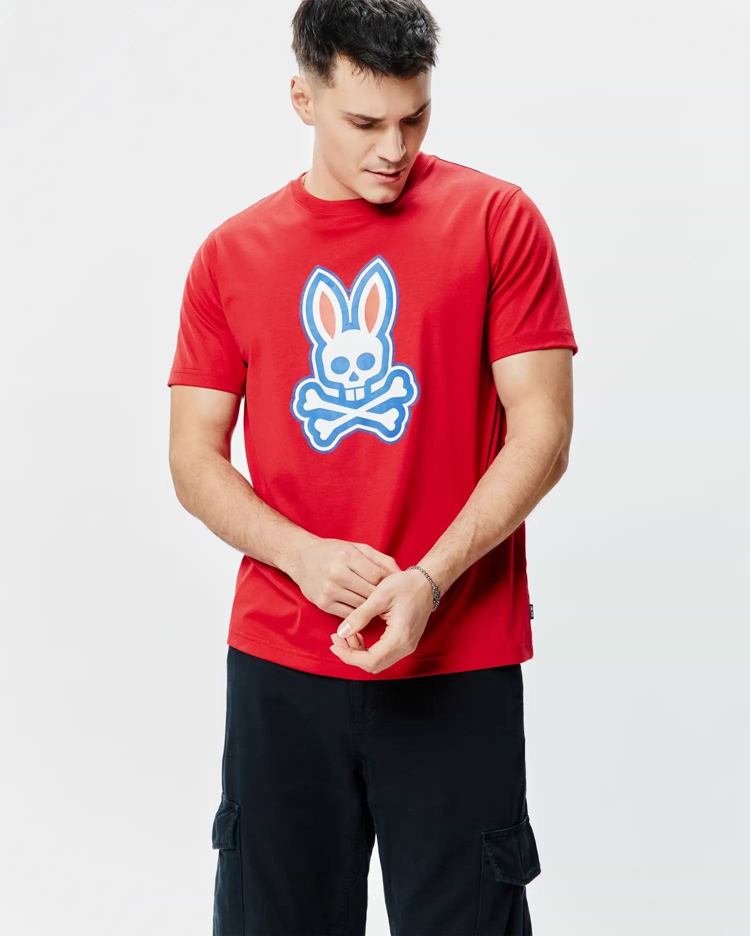 Mens John Graphic Tee, a classic fit red jersey t-shirt featuring a large white, light blue, and orange Psycho Bunny skull logo graphic centered on the chest.