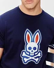 Mens John Graphic Tee, a navy blue classic fit jersey knit t-shirt featuring a large central chest graphic of the iconic Psycho Bunny skull logo in white, blue, and red with an embroidered outline.