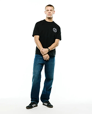 Mens Olek Relaxed Back Graphic Tee, a black relaxed fit soft jersey knit t-shirt featuring a small white circular Psycho Bunny skull logo with text on the left chest. (4)