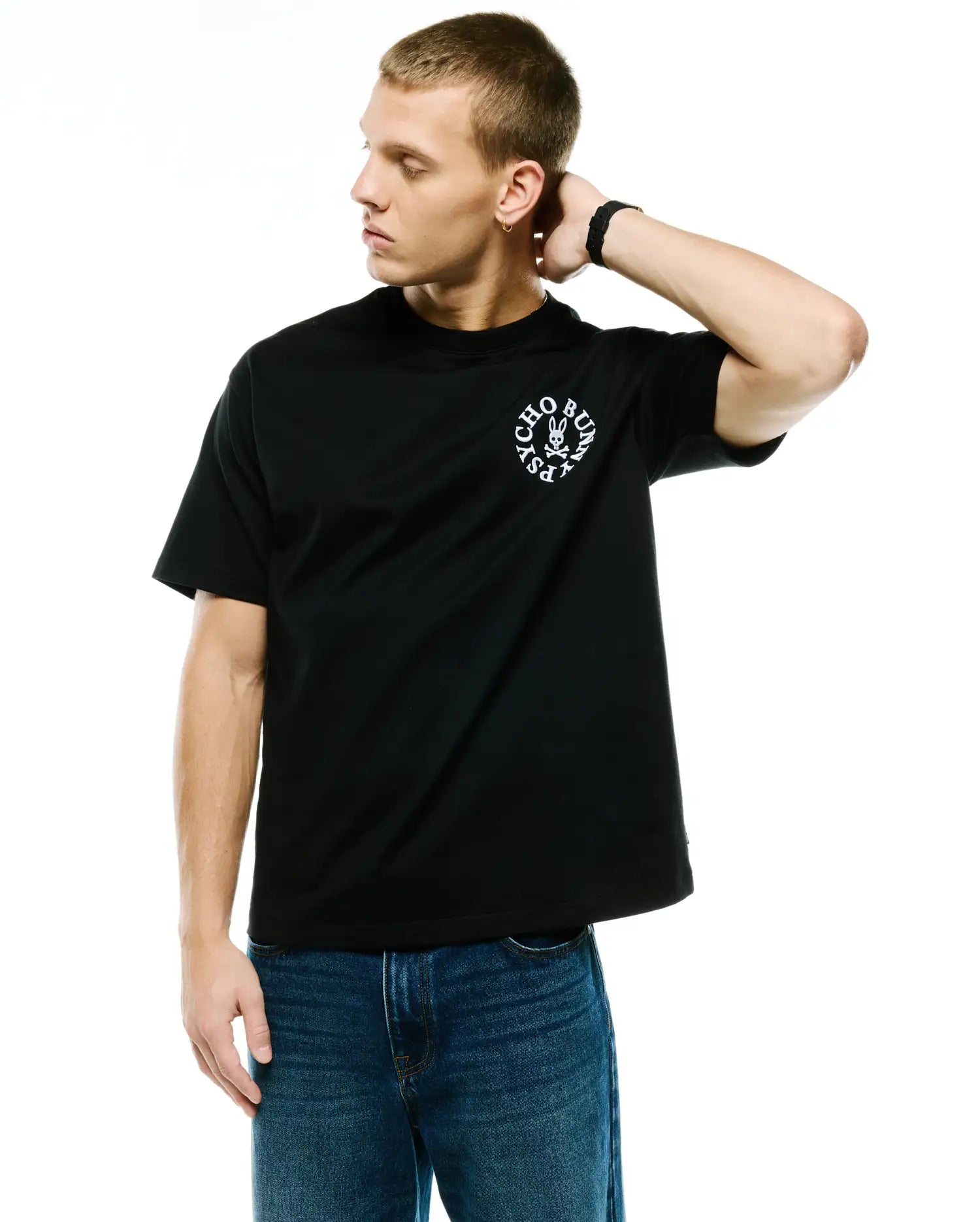 Black Mens Olek Relaxed Back Graphic Tee, crafted from smooth jersey fabric, featuring a prominent white circular Psycho Bunny skull logo graphic on the left chest. (3)