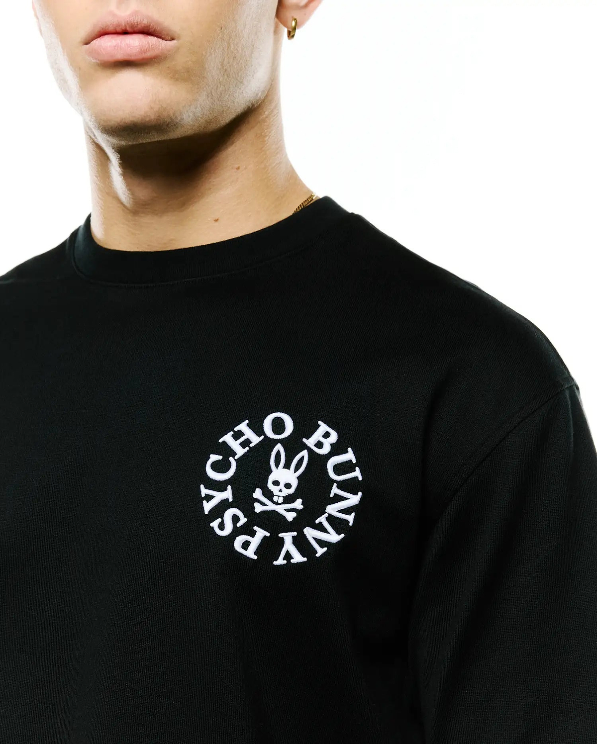 Mens Olek Relaxed Back Graphic Tee, black jersey knit with a relaxed fit, featuring a white embroidered circular Psycho Bunny skull and crossbones logo on the left chest. (2)
