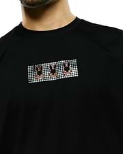Men's Alfie Back Graphic Tee, black classic fit jersey knit, featuring a chest graphic with three orange Psycho Bunny skull logos on a silver pixelated background. (3)