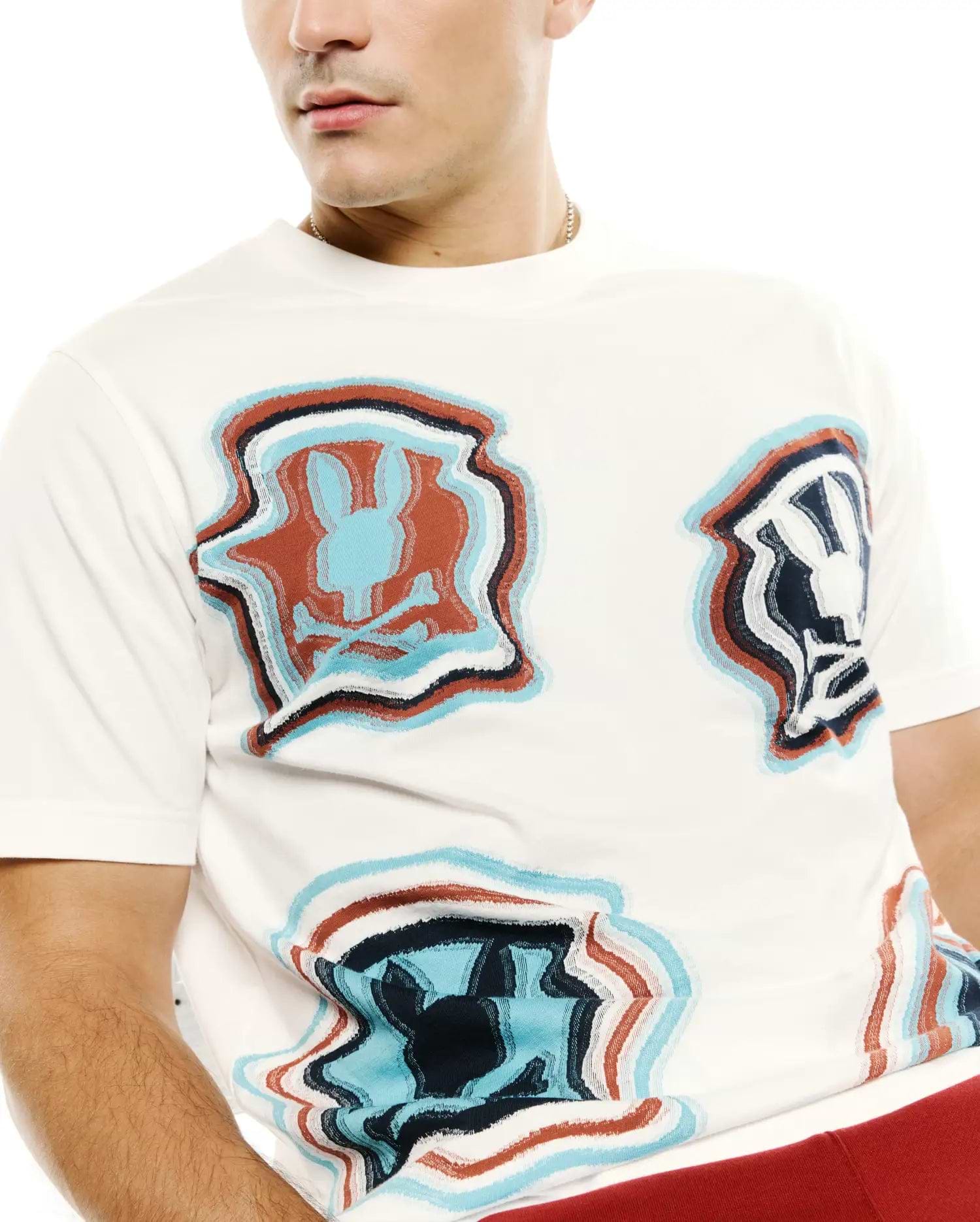Men's Klaus Jacquard Tee, a classic fit cream jersey t-shirt featuring an all-over distorted wavy Psycho Bunny skull logo jacquard pattern in teal, navy, rust, white, and black. (2)
