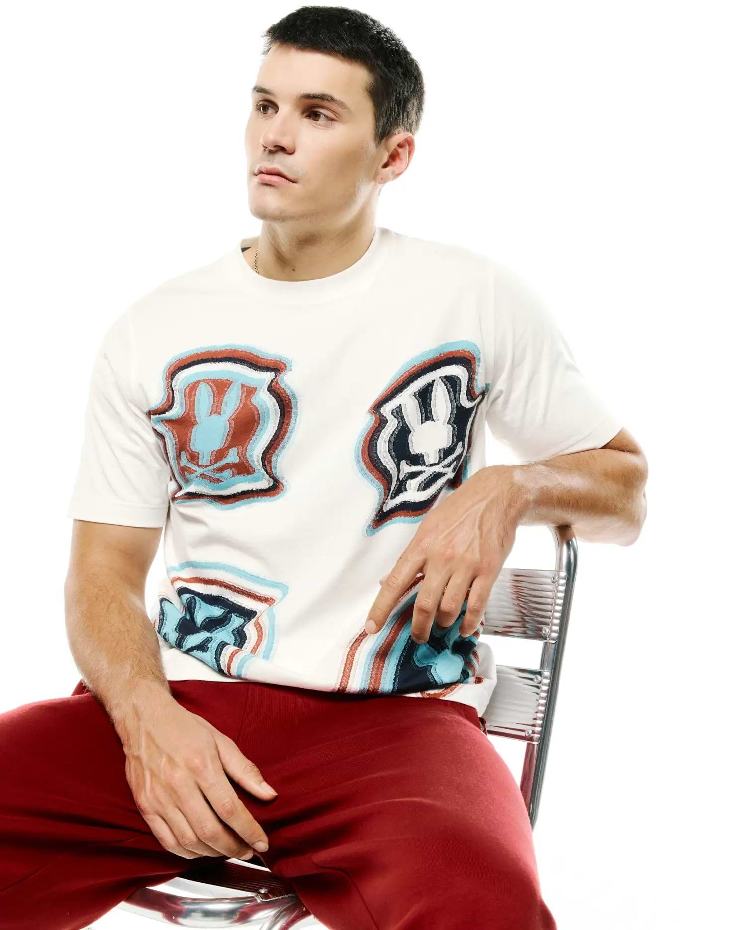 Men's Klaus Jacquard Tee, a cream relaxed-fit top with an all-over distorted blue, red, and black Psycho Bunny skull logo jacquard pattern. (3)