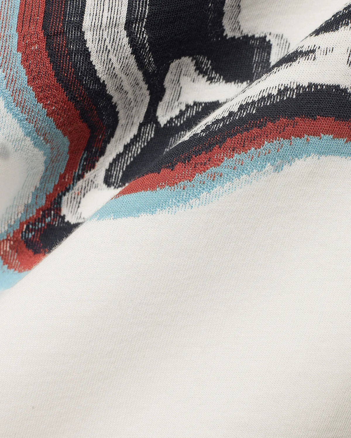 Men's Klaus Jacquard Tee featuring a cream jersey knit base with a bold jacquard pattern of black, white, red, and light blue wavy stripes. (6)
