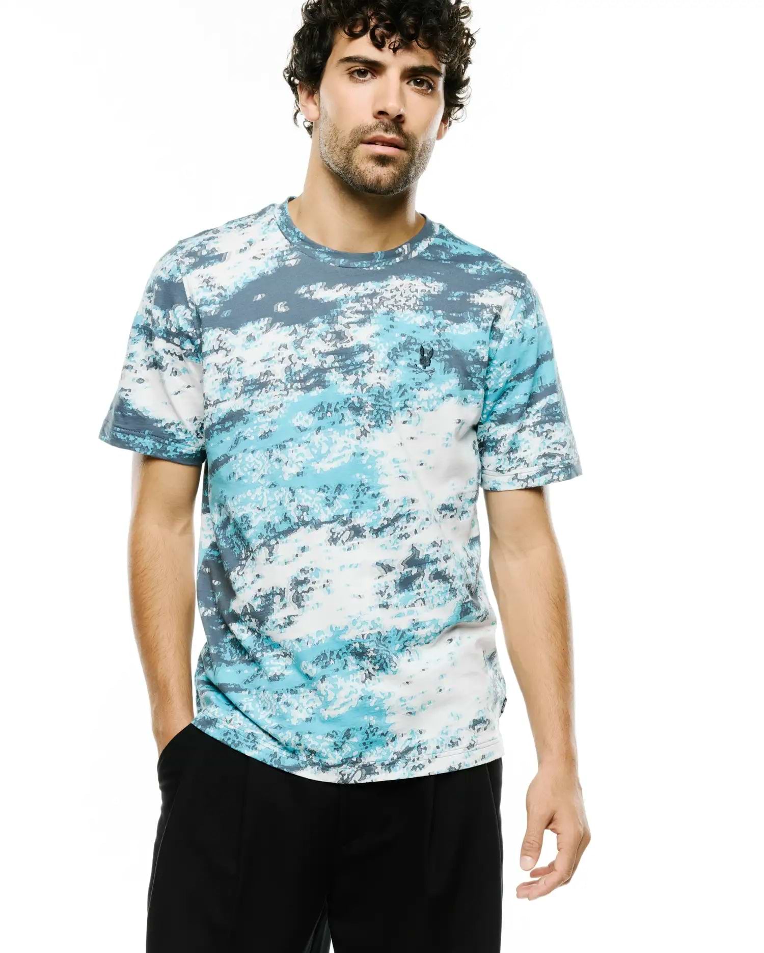 Men's Alfie All-Over Jacquard Tee, a classic fit knit t-shirt in white, light blue, and dark grey abstract pattern, featuring a small embroidered Psycho Bunny skull logo on the left chest. (3)