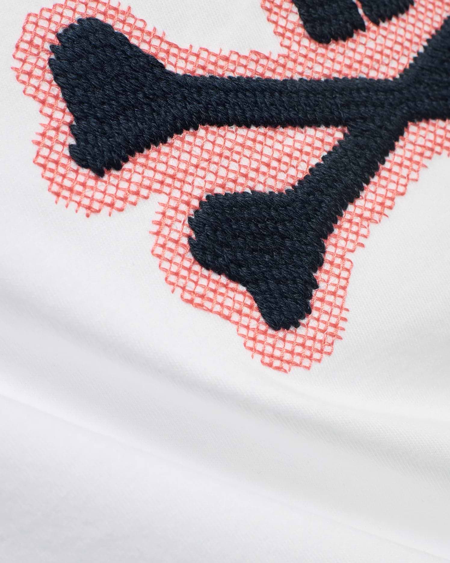 Men's Samson Graphic Tee in white soft jersey, featuring a prominent embroidered dark blue bunny skull logo with a coral cross-stitch outline. (6)
