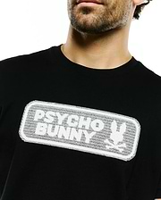 Black classic fit jersey T-shirt featuring a prominent white textured mesh graphic of the Psycho Bunny wordmark and iconic bunny skull logo on the chest. Men's Samson Wordmark Graphic Tee. (3)