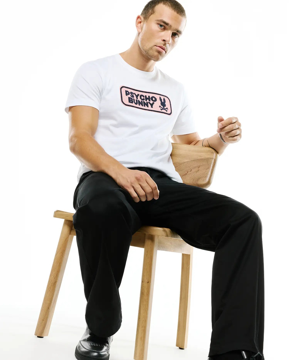 Men's Samson Wordmark Graphic Tee, a white classic fit jersey t-shirt featuring a prominent pink rectangular chest graphic with the black Psycho Bunny wordmark and skull logo. (2)