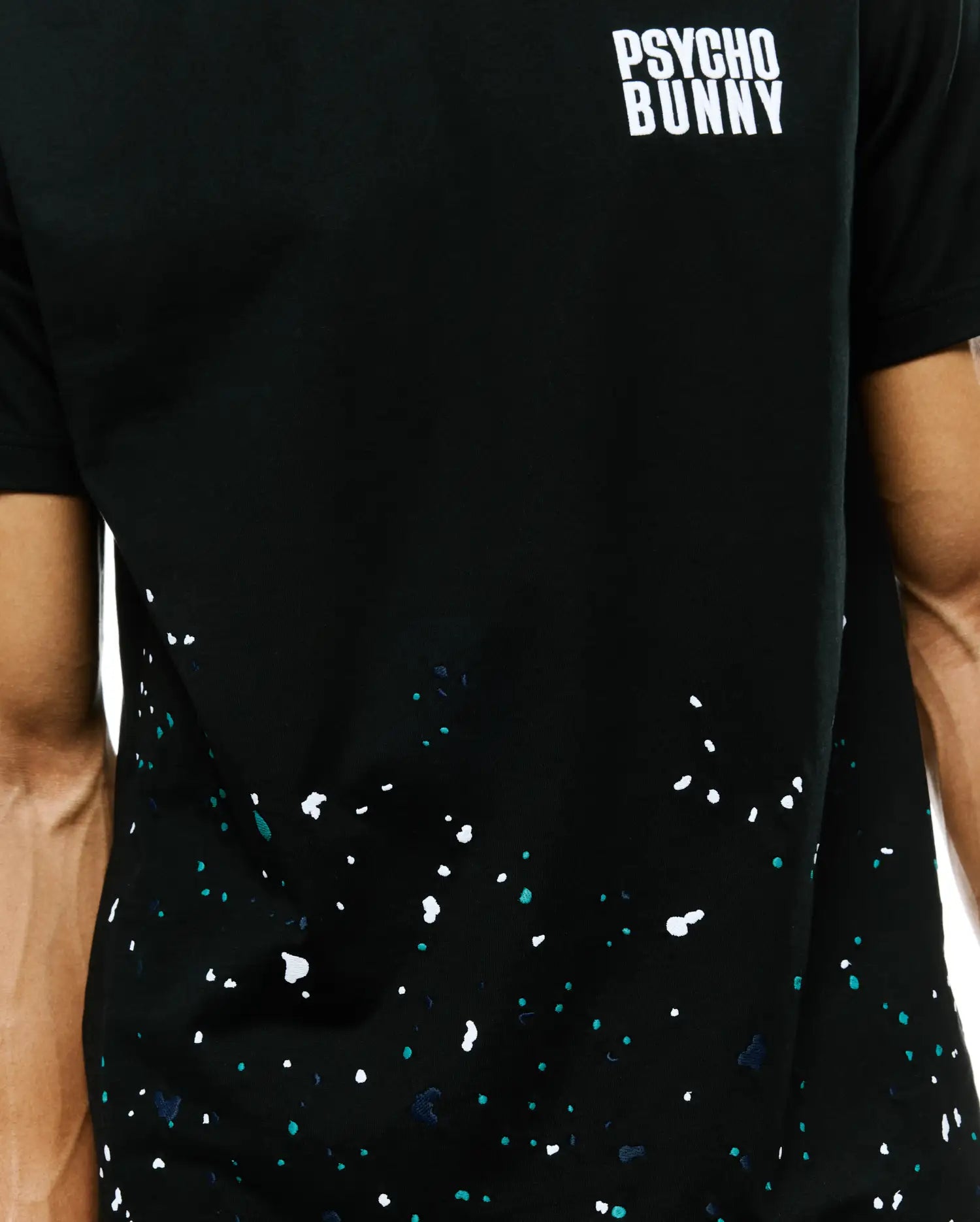 Mens Malcolm Graphic Tee, classic fit black jersey t-shirt featuring a white Psycho Bunny text logo on the upper chest and a vibrant white, teal, and navy splatter graphic.
