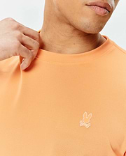 Mens Dash Bunny Sport Tee in peach pique knit, featuring a small white embroidered Psycho Bunny skull logo on the left chest, offering a classic fit. (2)