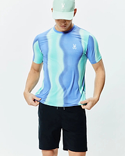 Mens Blaze Sport Tee in a vibrant blue and teal wavy gradient pattern, crafted from performance knit fabric with a classic fit and a small white Psycho Bunny logo on the left chest.