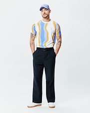 Mens Blaze Sport Tee featuring a classic fit, white jersey knit with bold wavy blue and orange stripes, and a small light blue Psycho Bunny skull logo on the left chest.