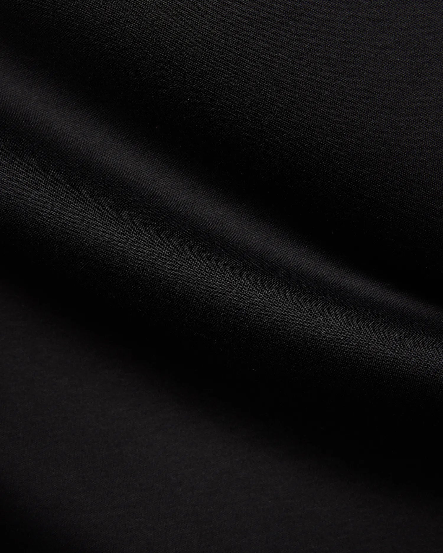 Psycho Bunny Mens Stevie Relaxed Fit Tee in deep black, made from smooth jersey fabric with subtle texture, featuring the iconic small embroidered bunny skull logo on the left chest.